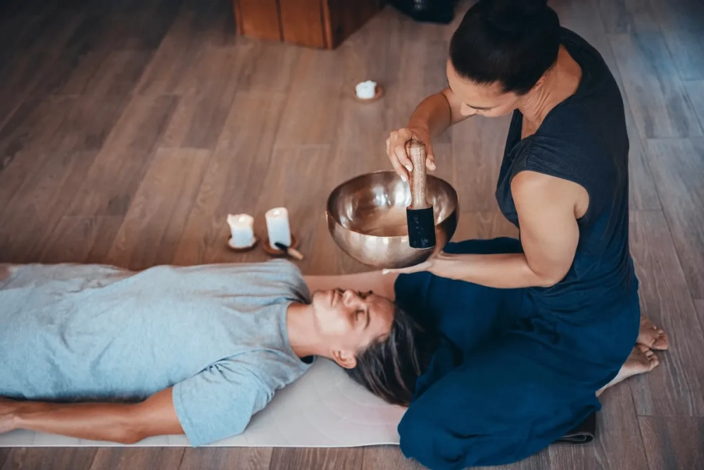 Một tách trà ấm đặt bên cuốn sách chữa lành trên bàn gỗ